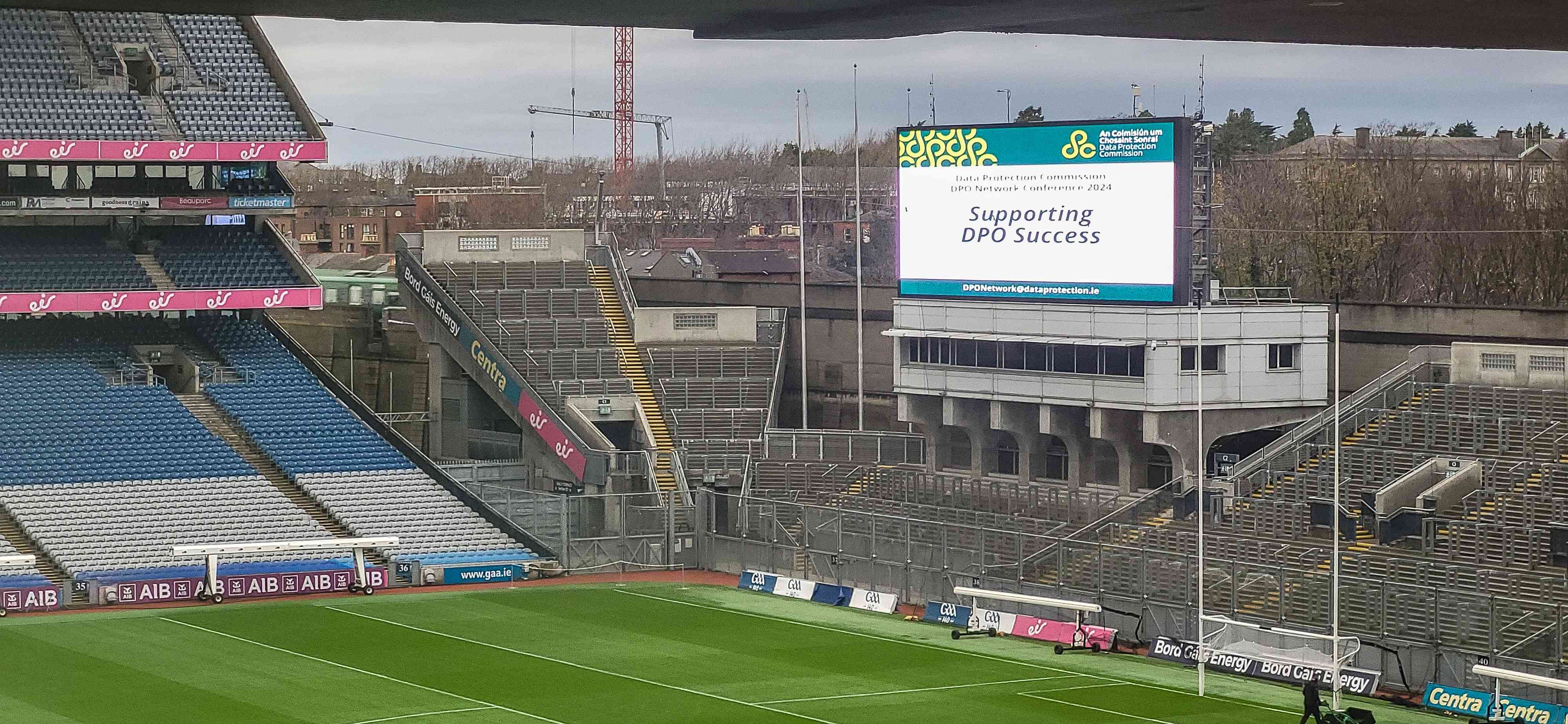 The Croke Park pitch and stand, with a large screen in the background which reads, "Data Protection Commission, DPO Network Conference 2024, Supporting DPO Success".